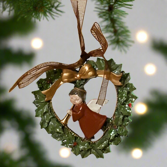 Decorative ornament with a heart-shaped wreath and figure, hanging from a ribbon.