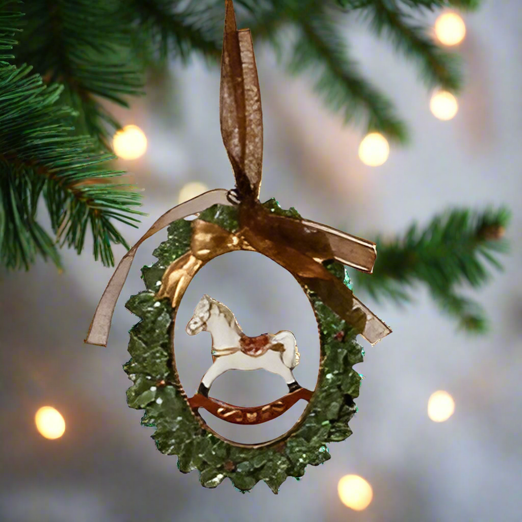 Decorative Christmas ornament with a horse silhouette on a green wreath.