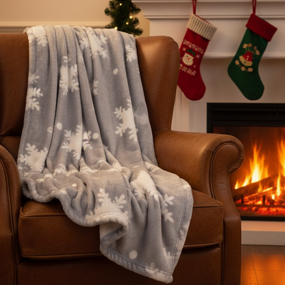 A grey blanket with a white snowflake pattern, folded or draped casually.