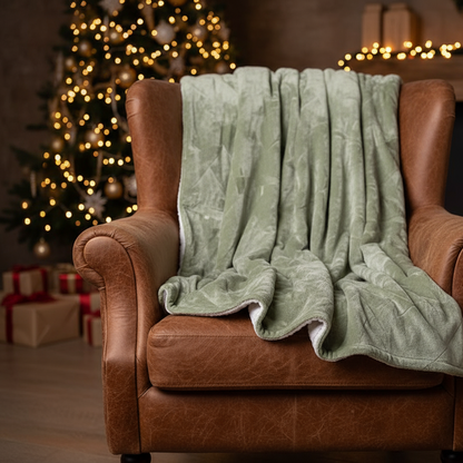 A folded green Christmas tree pattern throw with a sherpa-backed polyester flannel surface.