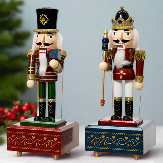 Two nutcracker figurines on decorative bases with a white background