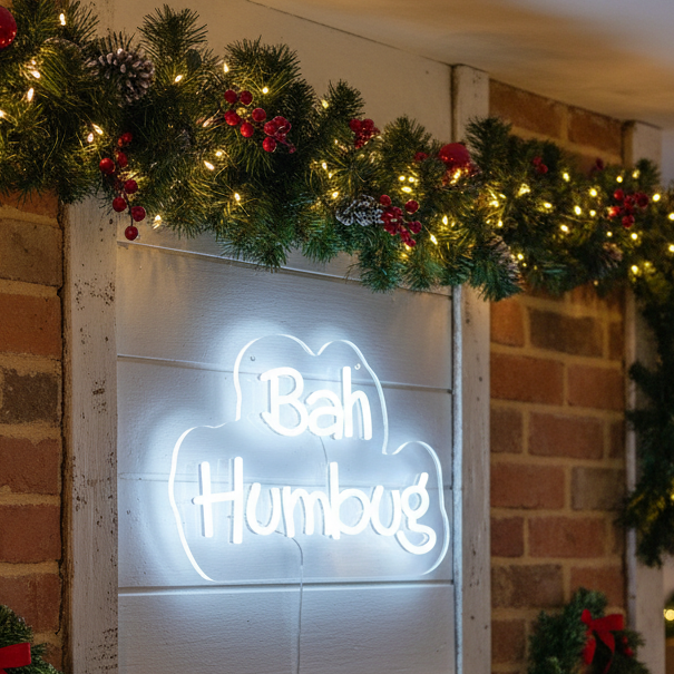 Decorative sign with 'Bah Humbug' text on a stand, illuminated against a festive background.
