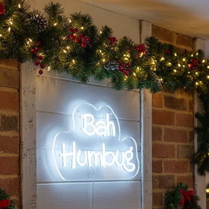 Decorative sign with 'Bah Humbug' text on a stand, illuminated against a festive background.