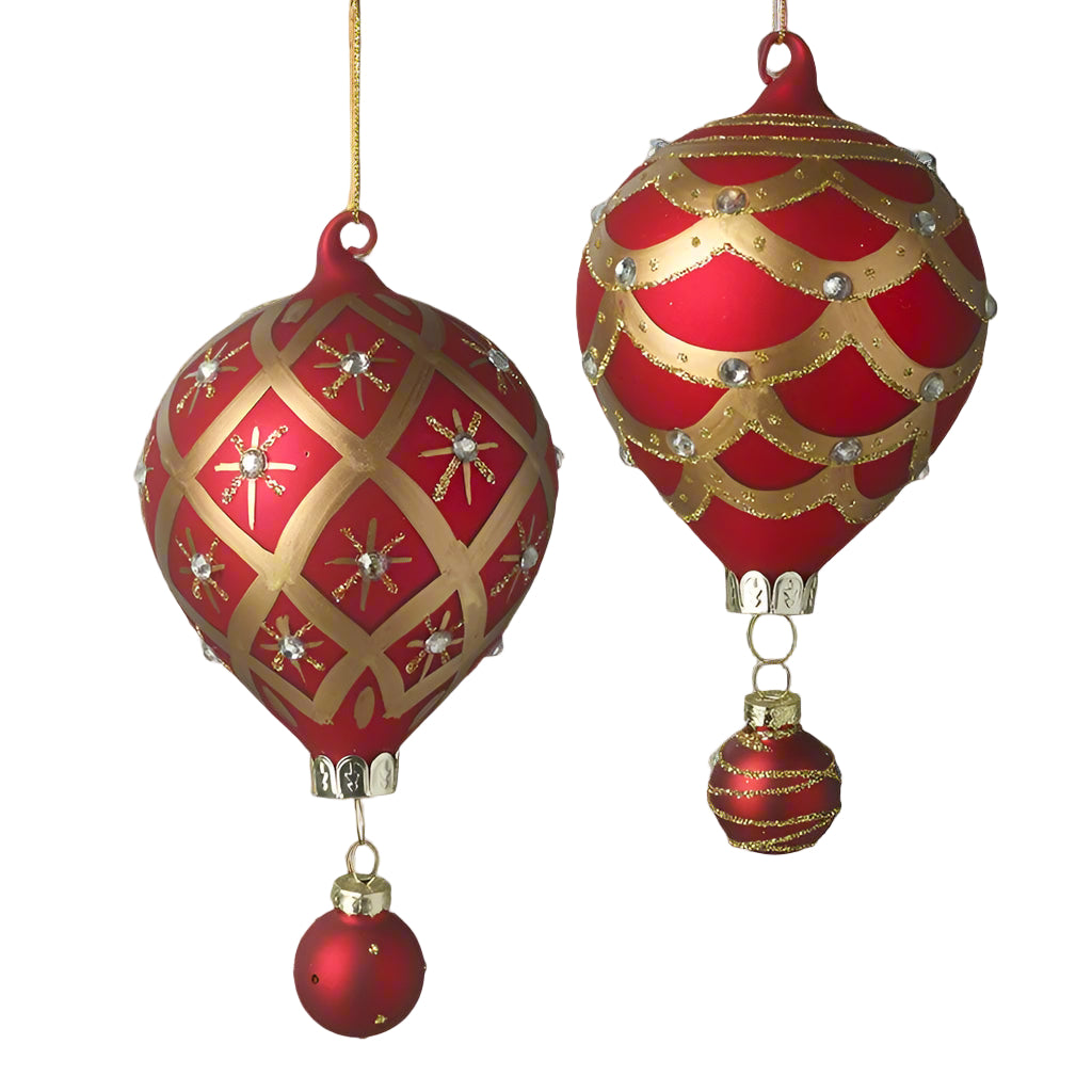 Two red and gold glass air balloon shaped holiday ornaments with gold hanging wire. One is larger with a solid gold pattern and the other is smaller with star patterns.
