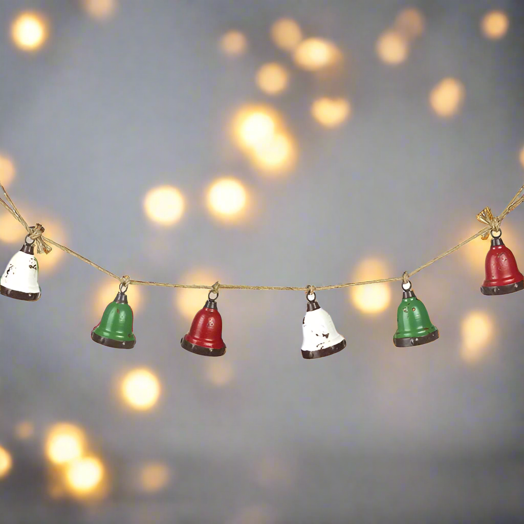 A garland of red, white, and green Christmas bells with a rustic jute hanging rope.