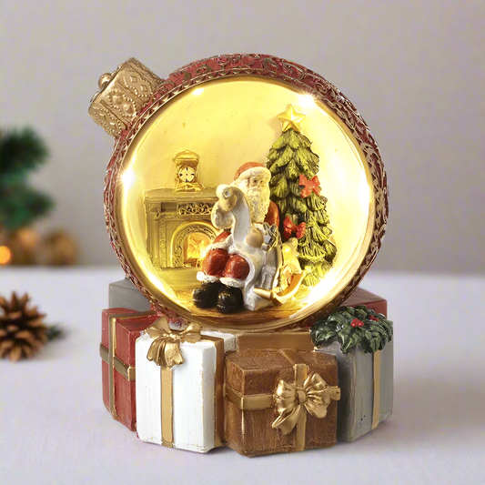 A resin LED Christmas ornament featuring Santa Claus inside a golden bauble, with a Christmas tree and presents in the background.