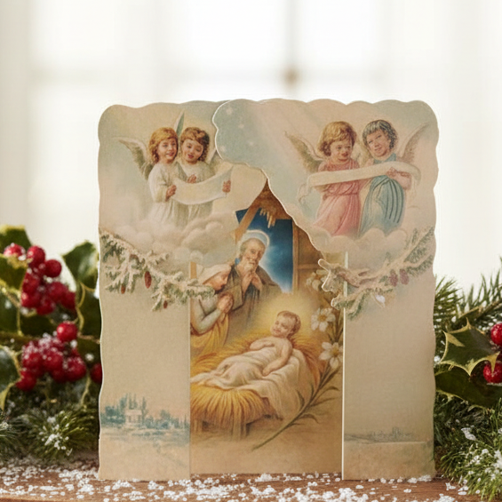 A die-cut and embossed Christmas card featuring a Victorian nativity scene with snow and angels, and an envelope.