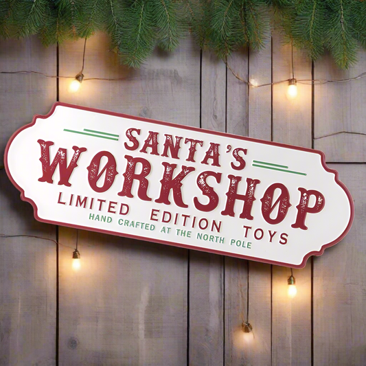 A metal sign with a red and white color scheme featuring the text 'Santa's Workshop Limited Edition Toys' and 'Hand Crafted at the North Pole'.
