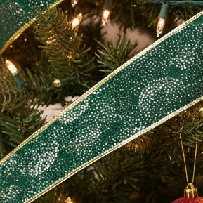 A length of dark green Christmas ribbon with a gold pattern and edging, displayed against a white background.