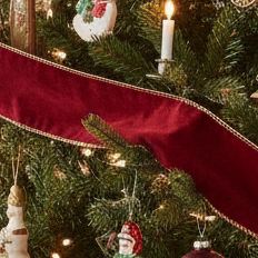 A length of burgundy velvet Christmas ribbon with gold edging, displayed against a white background.