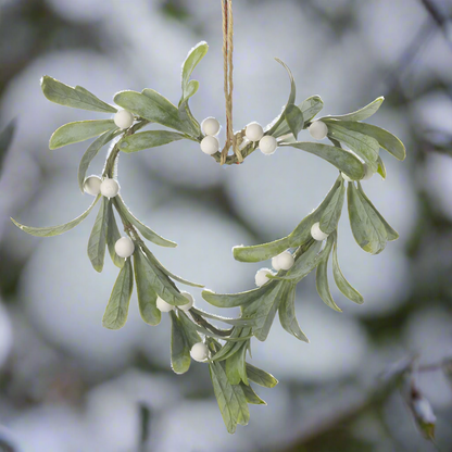A heart-shaped mistletoe wreath with jute rope hanger, featuring green leaves and white berries.