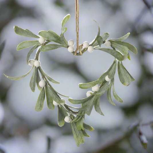 A heart-shaped mistletoe wreath with jute rope hanger, featuring green leaves and white berries.