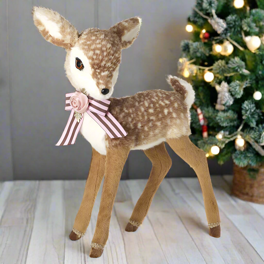 A plush toy deer with a pink rose and bow attached to its neck.