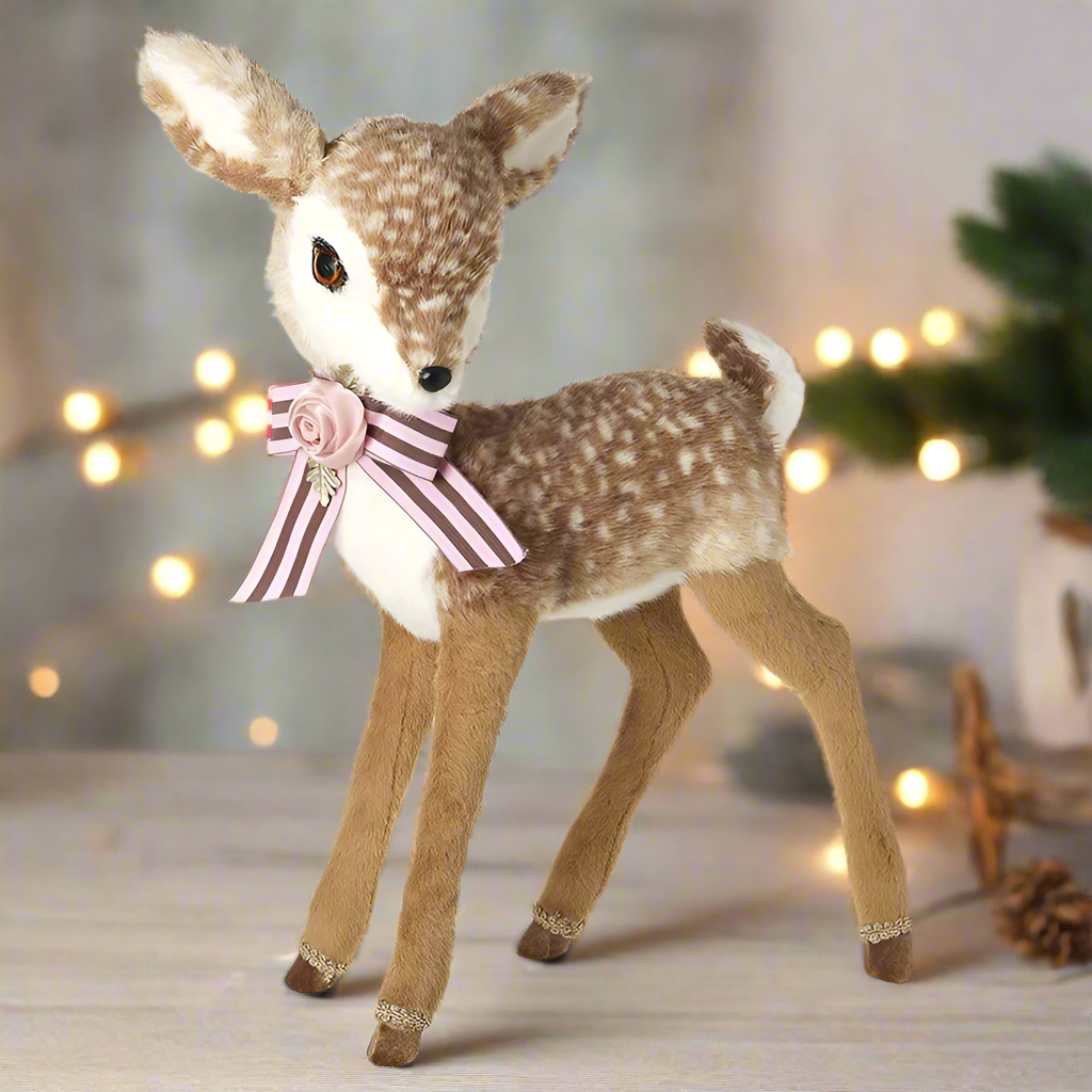 A plush toy deer with a pink rose and bow attached to its neck.