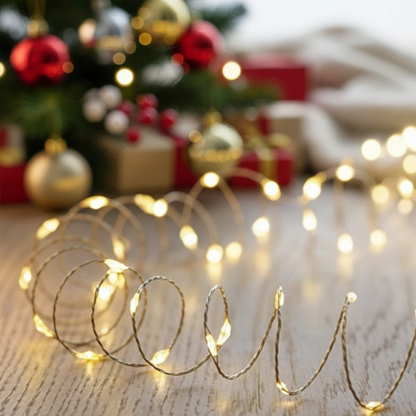 A string of warm white microbright LED pin wire lights placed on a flat surface, creating ambient lighting.