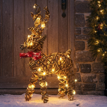 Decorative reindeer and wreath on a stone house door at night