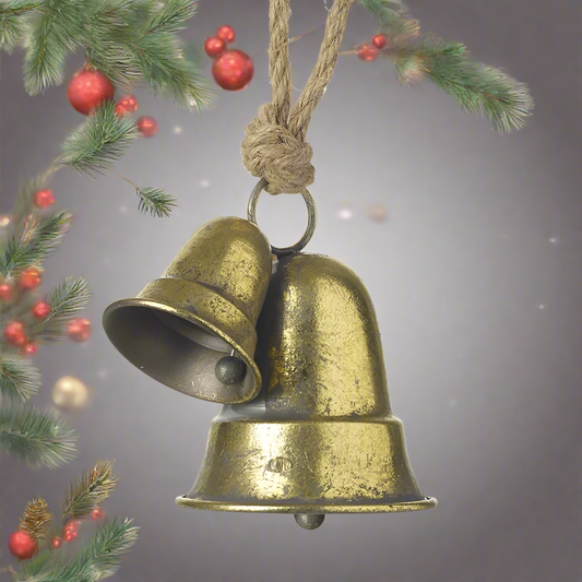 A gold metal Christmas bell decoration with two bells joined together, hanging from a twine.