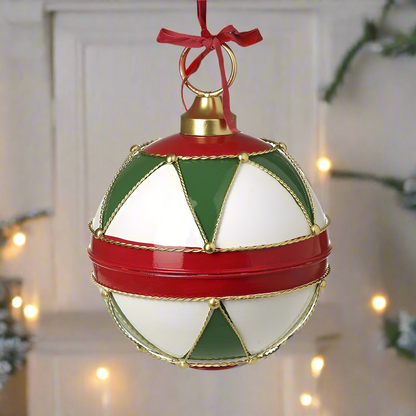 A large round Christmas ornament with red, green, white, and gold geometric patterns, featuring a gold top and a red ribbon hanger.