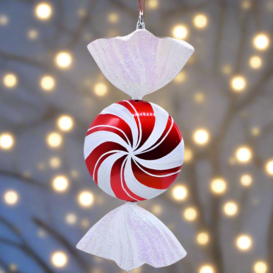 Decorative candy cane ornament with a white top and bottom against a blurred light background