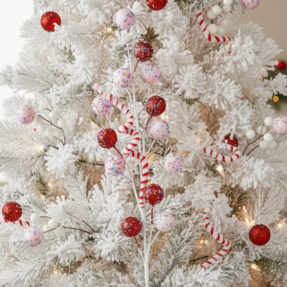 A decorative Christmas stem with a variety of berry and candy cane shaped ornaments in pink, red, and white colors, with green and white striped candy canes.