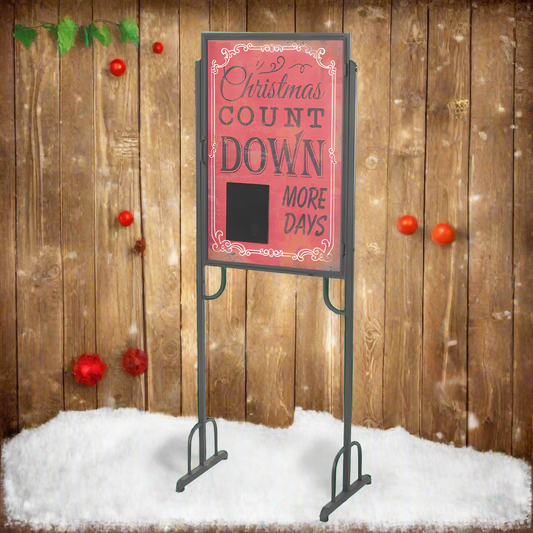 Christmas countdown sign on a stand with a wooden background and snow at the bottom.