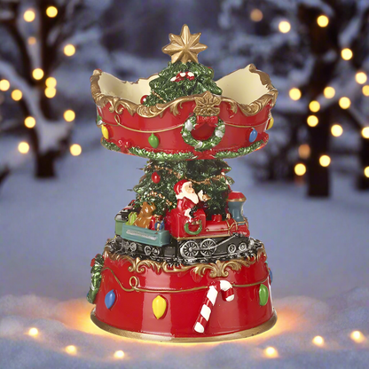 A decorative Christmas ornament featuring Santa Claus sitting on a train with a spinning base, decorated with a Christmas tree and festive elements.