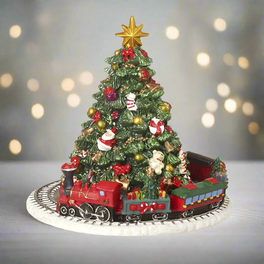 A musical Christmas tree ornament with a train base, featuring a Christmas tree decorated with ornaments and a star on top, revolving around a small train.
