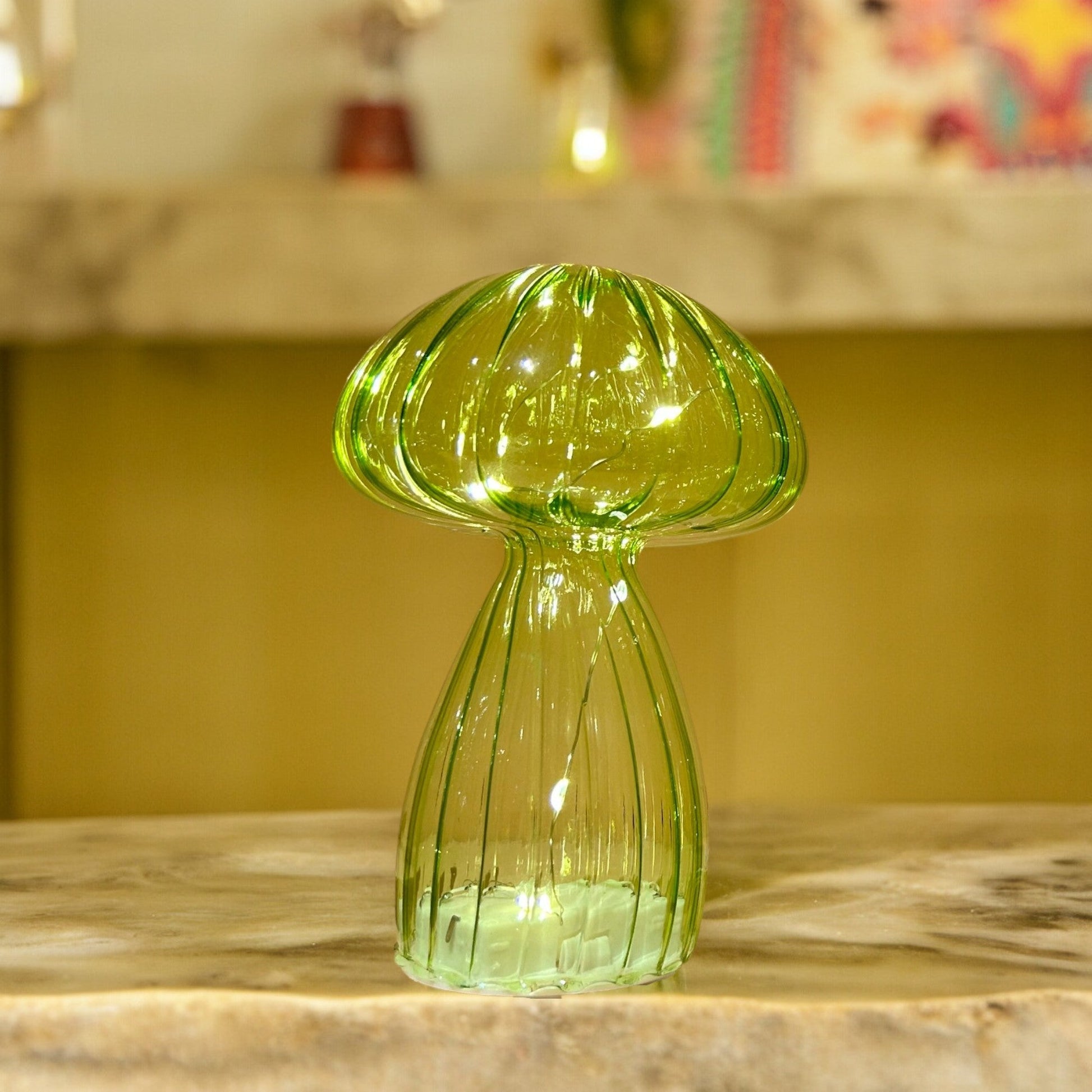 Green glass vase on a marble surface with a blurred background