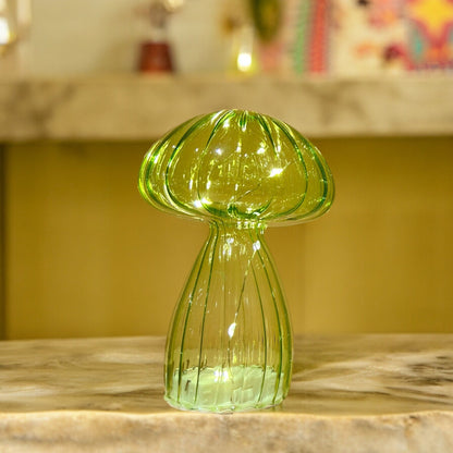 Green glass vase on a marble surface with a blurred background