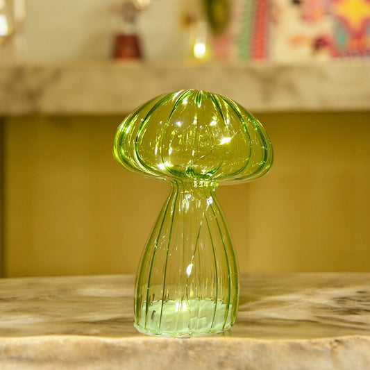 Green glass vase on a marble surface with a blurred background