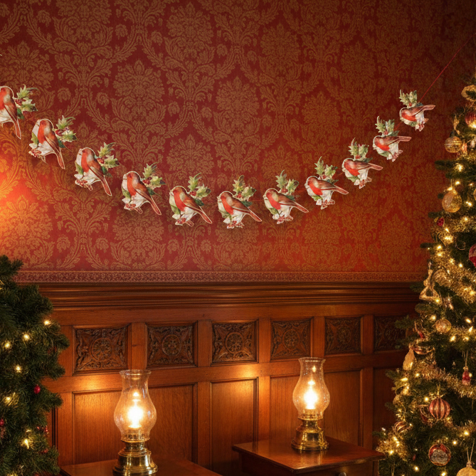 A die-cut and embossed paper garland featuring repeated motifs of a robin and holly, with a length of 3 meters and a height of 17.5 cm.
