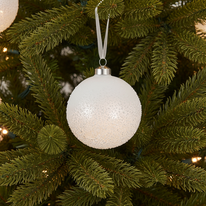 White textured Christmas ornament on a green tree