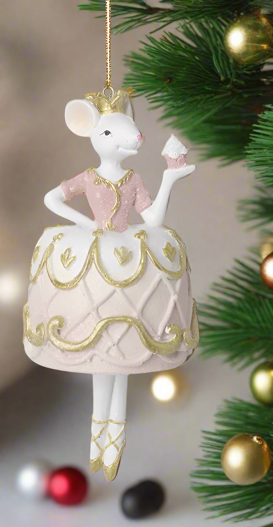 A decorative mouse ballerina figure with gold and pale pink colors, hanging from a string, posed on one leg with a crown on its head.