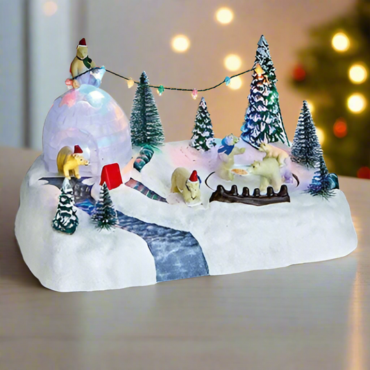 Decorative winter scene with miniature figures and lights on a white surface.